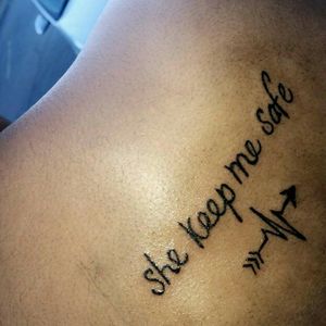 "she keeps me safe"- back tattoo on female
