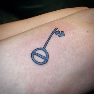 Custom designed Non Binary/Trans key, coloured in blue, on the client's right thigh