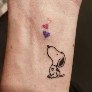 A tiny Snoopy with tinier hearts (and a bleedy white heart!) on the inside of the client's left wrist