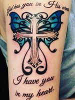 Tattoo I got of a blue Monarch Butterfly with a cross in the middle. It says "God has you in his arms, I have you in my heart." It's written in script. Got this tattoo for my sister that passed away on 08/03/2015 and my best friend that passed away on 02/02/2012. 