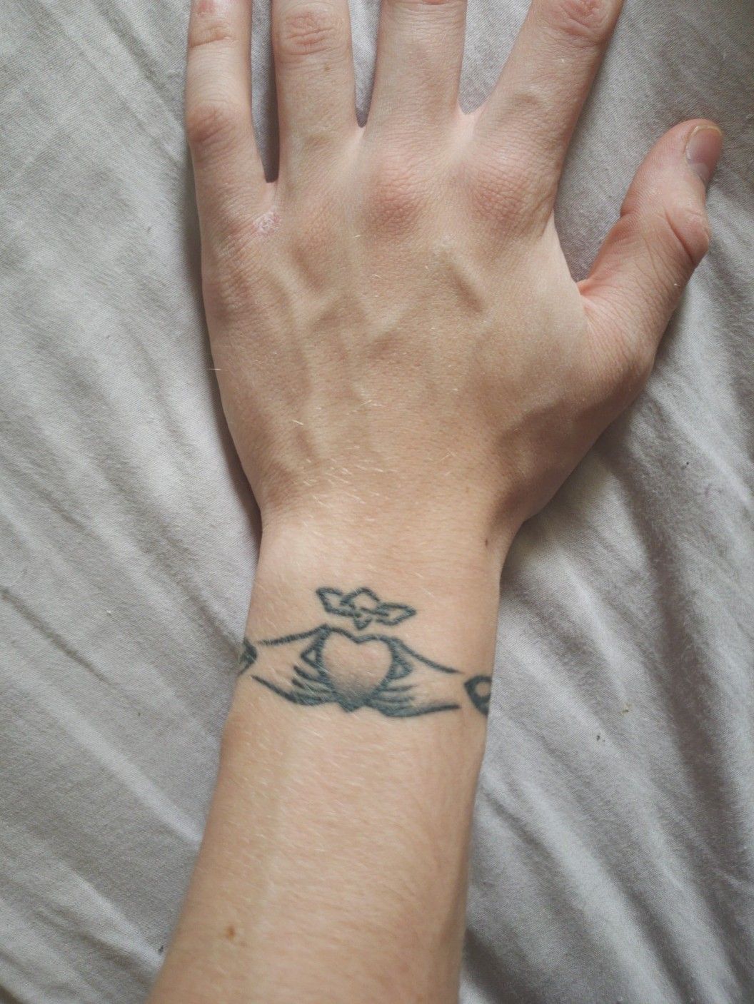 Grey Ink Small Claddagh Tattoo On Finger