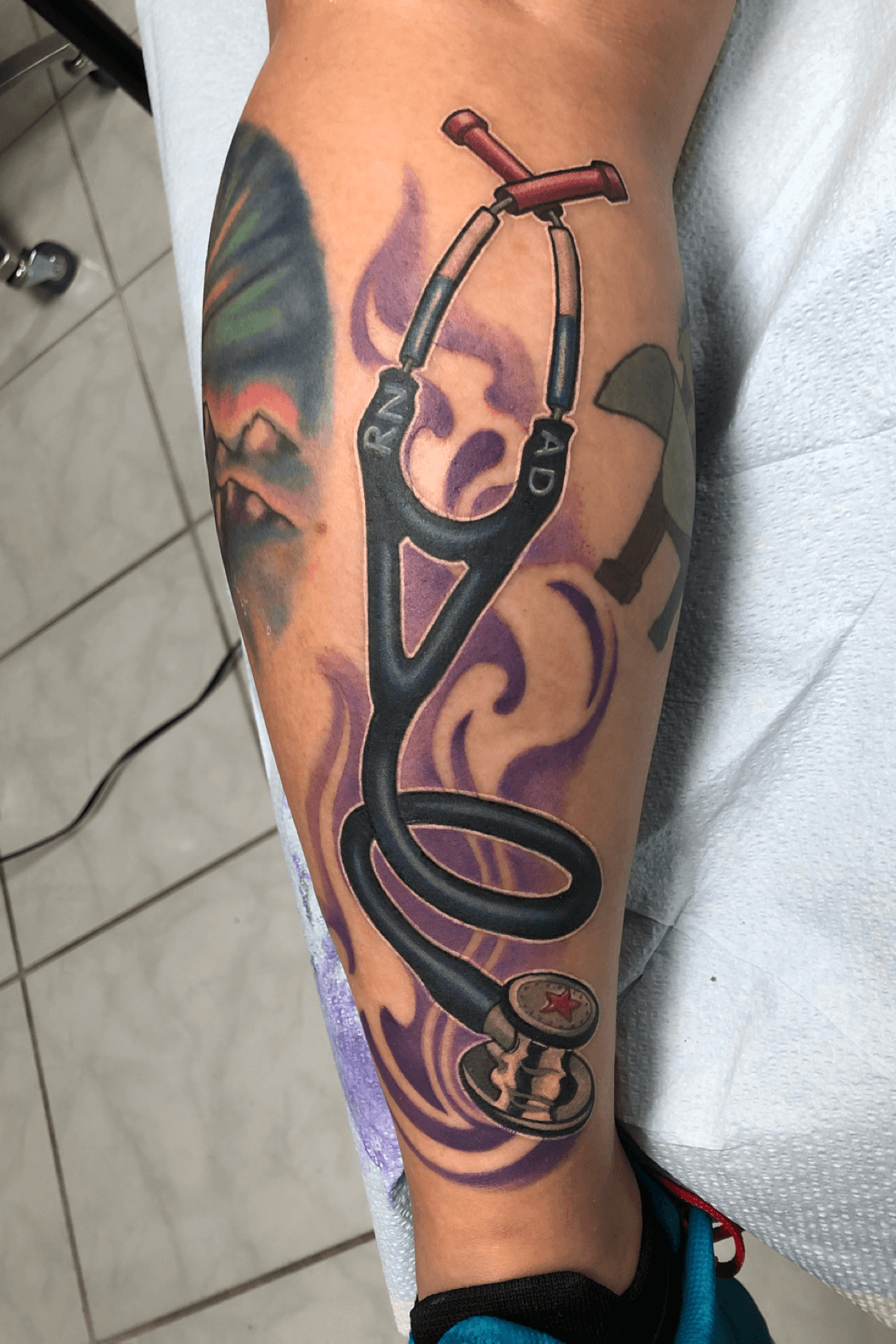Hand poked stethoscope tattoo located on the bicep