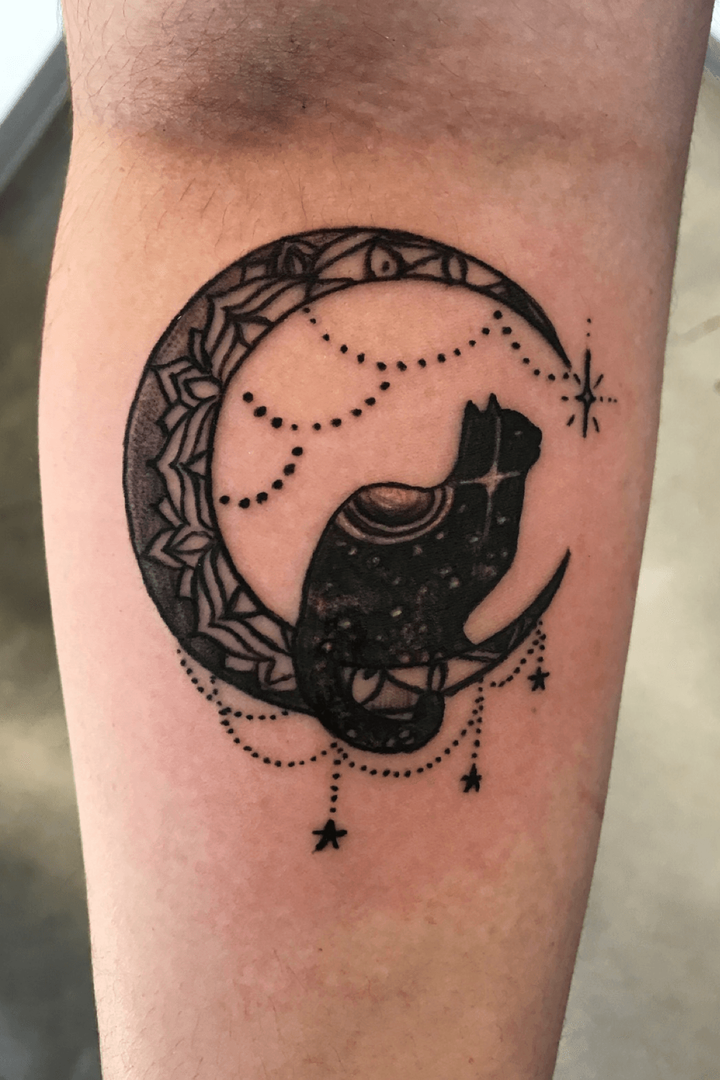 Crescent moon and cat tattoo located on the inner arm