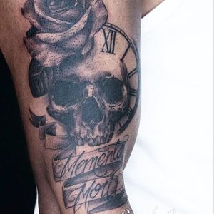 Get an edgy blackwork tattoo on your upper arm featuring a unique fusion of flowers and skulls, expertly crafted by tattoo artist Alex Santo.