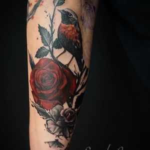 Vibrant forearm tattoo featuring a beautiful flower and brush strokes, expertly done by Alex Santo.