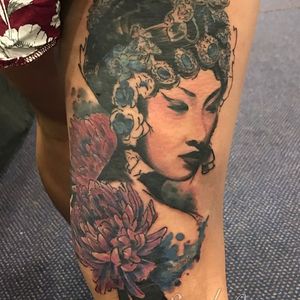 Alex Santo's stunning upper leg tattoo features a beautiful watercolor sketch of a woman with a flower motif.