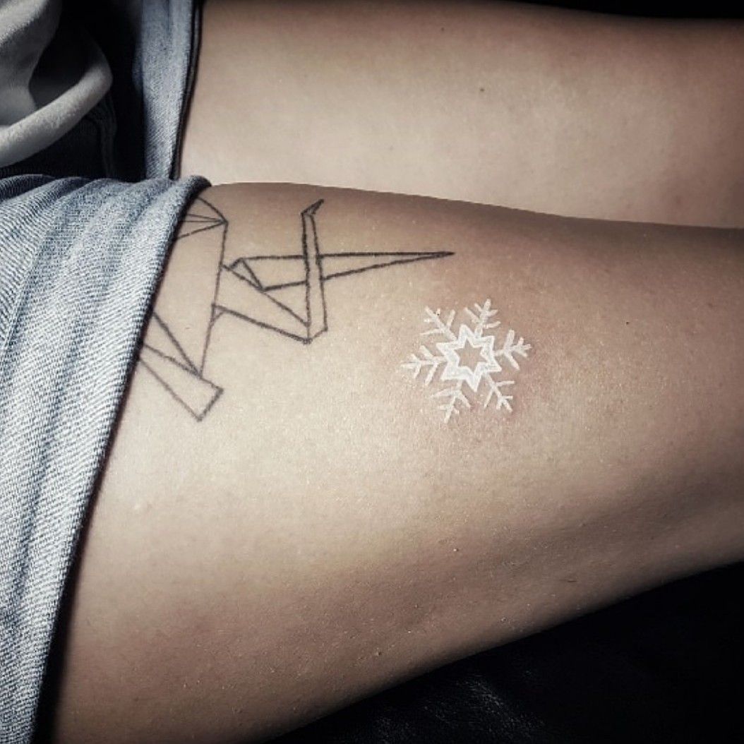 White ink snowflake tattoo on the wrist