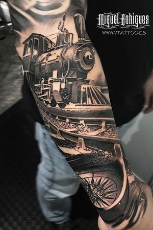 Realistic tattoo on the arm, a train with a compass