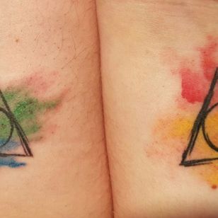 Matching sister tattoos. Hers is mostly yellow for #hufflepuff and mine is mostly green for #slytherin. #harrypotter #deathlyhallows #hogwartshouses #watercolour 