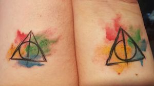 Matching sister tattoos.  Hers is mostly yellow for #hufflepuff and mine is mostly green for #slytherin.  #harrypotter #deathlyhallows #hogwartshouses  #watercolour 