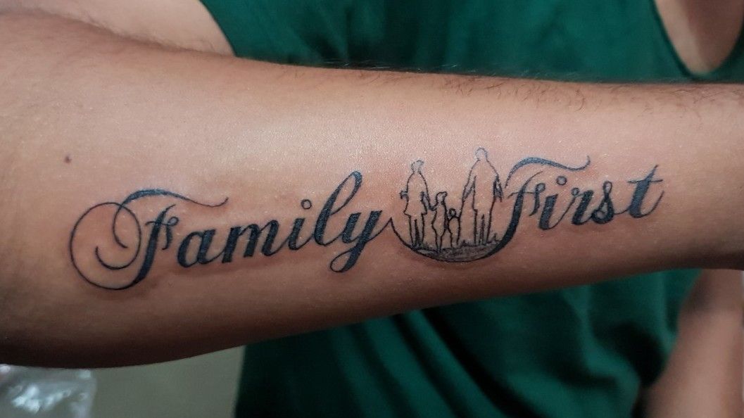 Family first lettering tattoo on rib