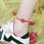 A red knotted anklet around the ankle by SION (@tattooistsion) #flowertattoo #floraltattoo #Korea #KoreanArtist #tattooistsion #colortattoo #flower #flowers #oriental #ankletattoo 