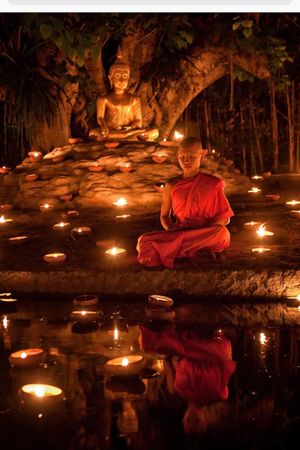 Statue and candles floating in the water. 