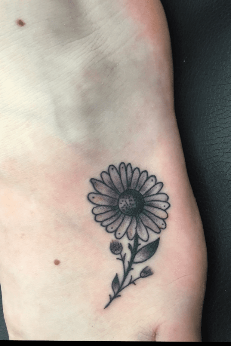 Fine line daisy tattoo on the ankle