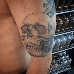 100% healed skull realistic black and grey with opaque greys and a hint of color upperarm tattoo.