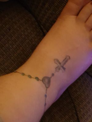 Blue rosary beads and a cross onto my foot...
