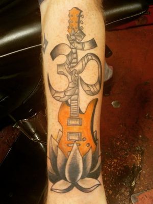 This is a Memorial piece for my best friend who died from Cancer. He was an artist and bhudist so I gave the tattoo artist a picture of his guitar and told him about his religion and the is what the artist designed for me. 