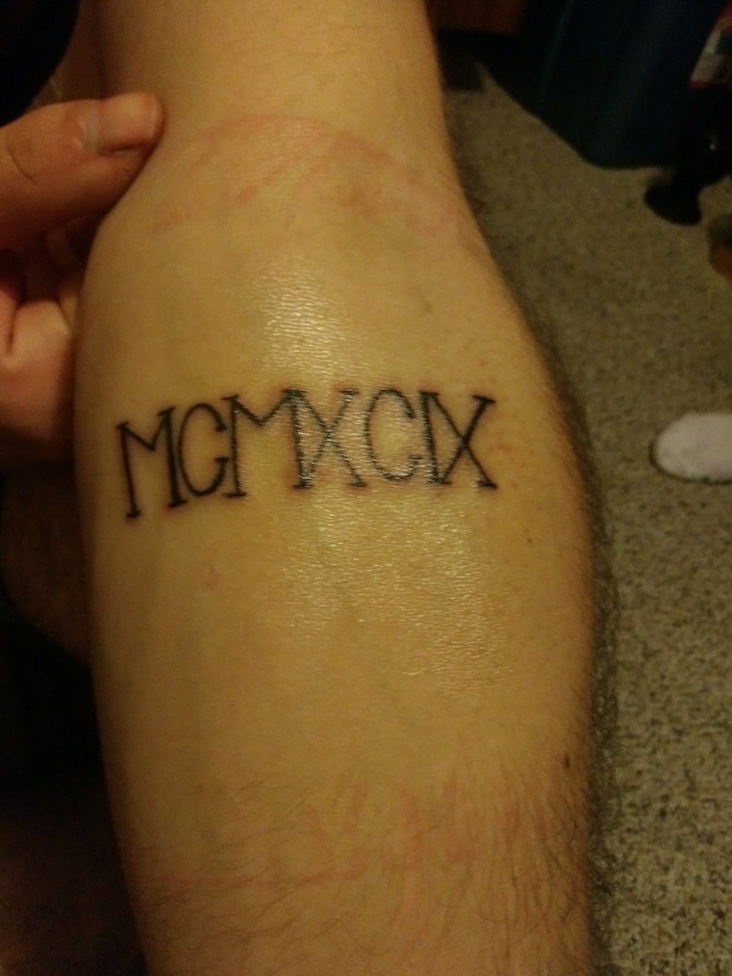 1999 lettering tattoo located on the bicep