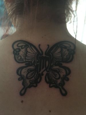 Butterfly tattoo with Virgo star sign as the body on top of spine 
