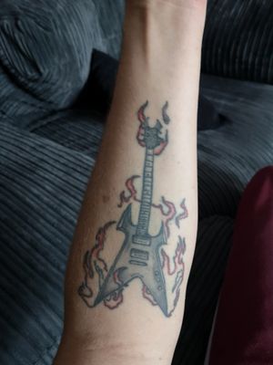 Tattoo of a guitar I own with flames. Guitar: BC Rich KK Beast V.Location: Left inner forearm.Apx 7 year old tattoo, faded lots!