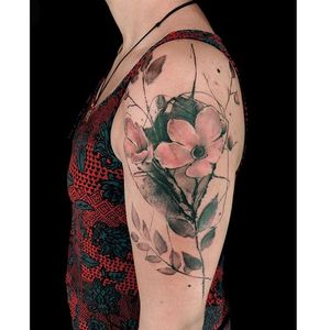 Express your love for nature with a stunning illustrative flower and leaf tattoo on your upper arm. Designed by La Bottega dell'Arte.