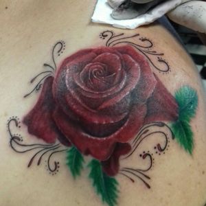 rosa realista com arabescos femininos, tattoo feita por Leidy
