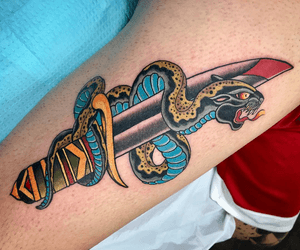 A traditional illustrative masterpiece by artist Darren Brass, featuring a coiled snake, fierce panther, and sharp dagger on the forearm.