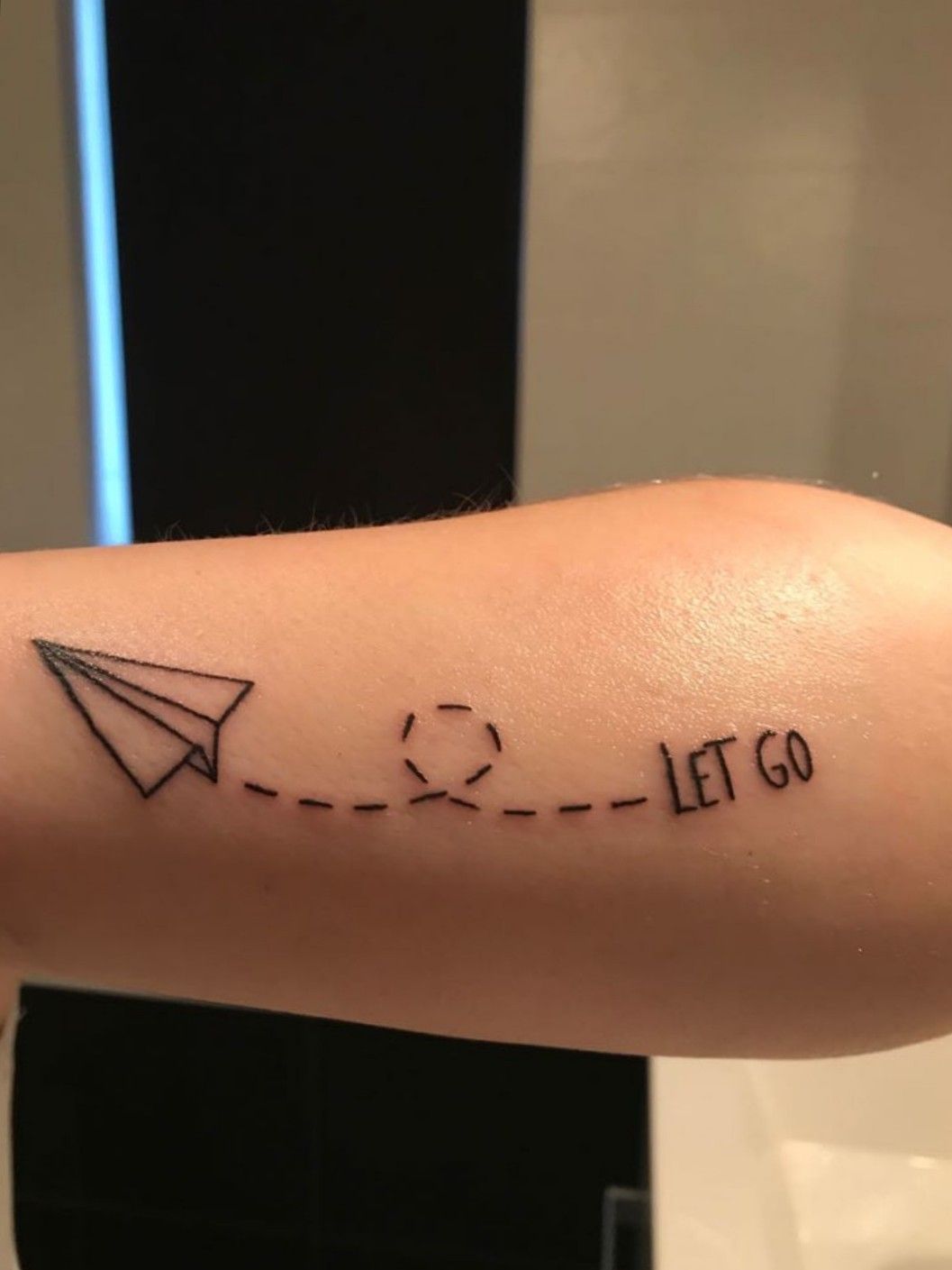 Tattoo that says let go handwritten on the wrist