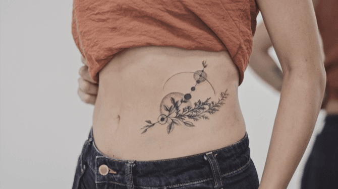 Watercolor flower tattoo on the pelvis