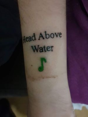 Avril Lavigne head above water tattoo.