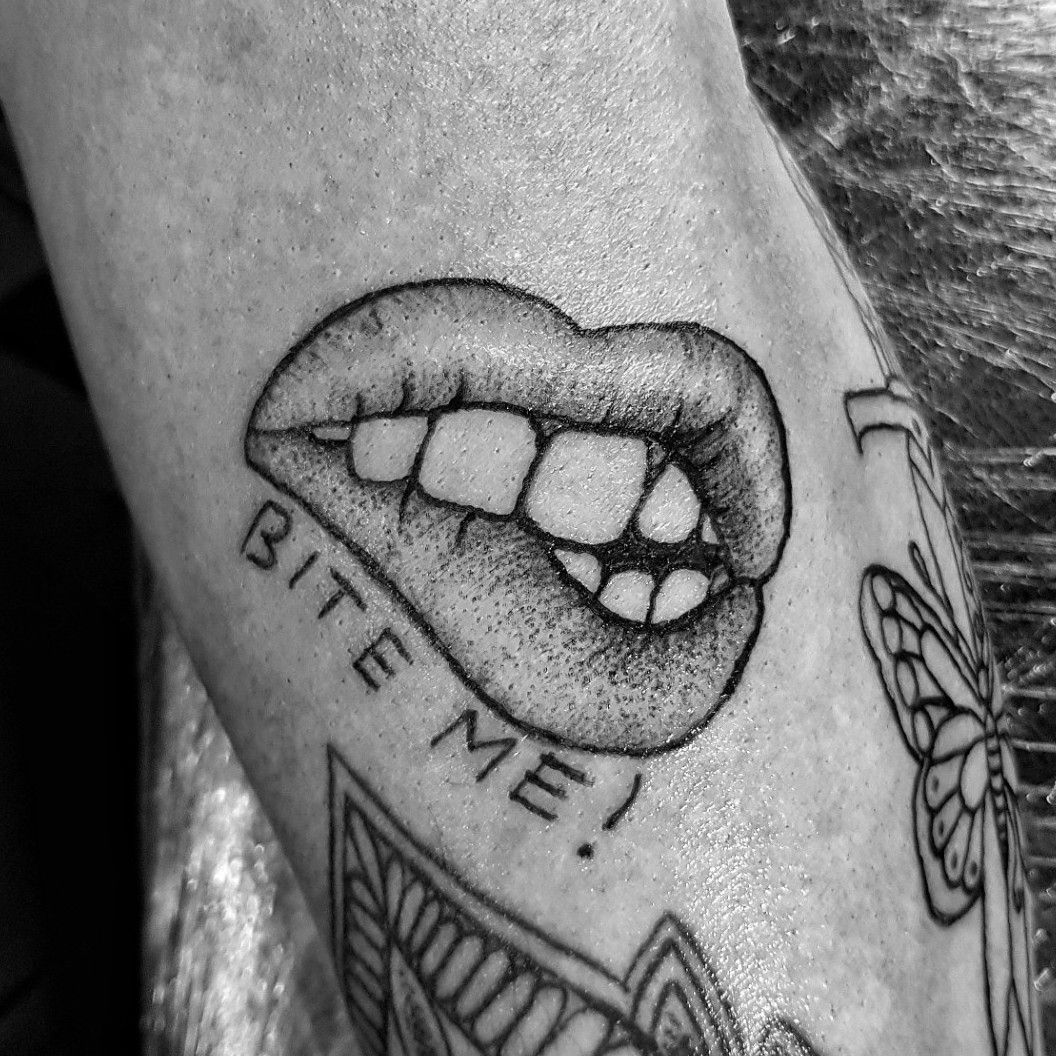 Bite me lettering tattoo located on the inner