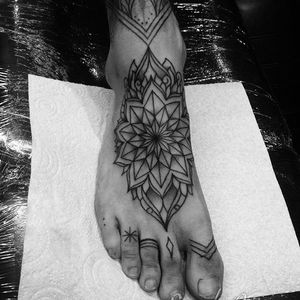 Get a stunning mandala tattoo on your foot in London. This geometric design will add a touch of elegance to your style.