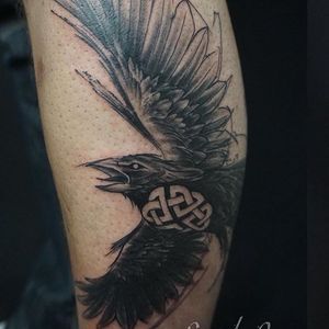 Get a stunning black and gray illustrative raven tattoo on your lower leg in London, GB. Embrace the mysterious beauty of this majestic bird.