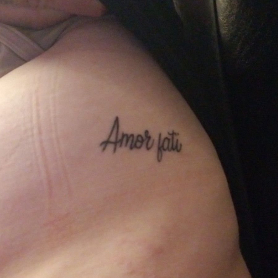 Amor fati and arrow tattooed on the wrist