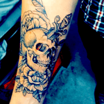 Skull w/ a dagger through the top w/ paired floral at top and bottom