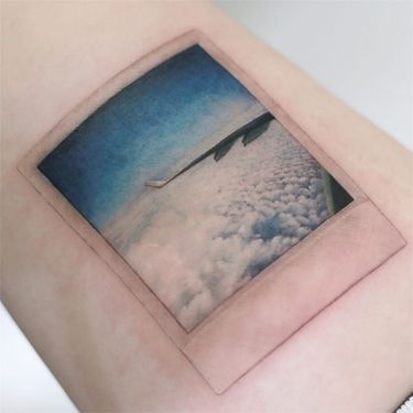 Tattoo by Tattooist Doy #TattooistDoy #realismtattoos #hyperrealismtattoos #realism #hyperrealism #realistic #airplane #travel #sky #polaroid #clouds