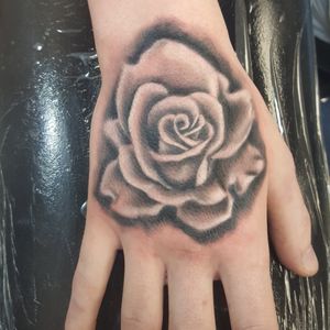 Hand tattoo.Black and grey rose