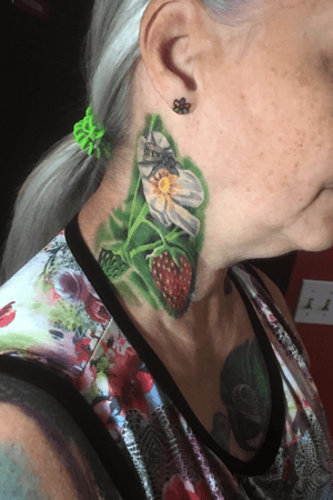 Heaed realistic strawberries, flower, and bee on a super tough client. Also pictured is a small rainbow flower on her ear. 
