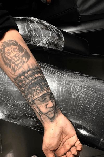 Realistic black and gray tattoo of a native woman, done by Simon Says Ink. Detailed features and intricate shading capture the beauty and strength of the subject.