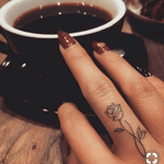 Geometric small flower finger tattoo