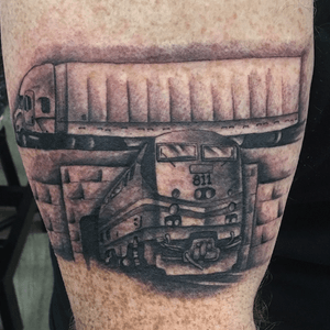 Black and grey train and semi truck tattoo on arm. 