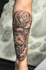 Black and grey realistic tattoo. Pocketwatch and roses