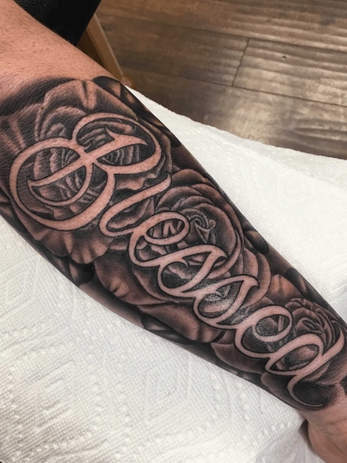 Black shaded simple blessed tattoo on full forearm for men
