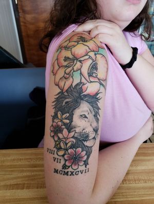 Got the flowers first for my 20th birthday. Got the lion added and Roman numerals around my 21st birthday. The gladiolus flowers represent my birthday as well as the lion. And the Roman numerals are my birthday. Tattoo done by Alex Boyles. 