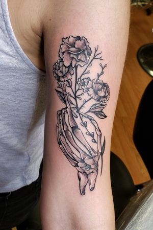 Skull hand holding carnations 