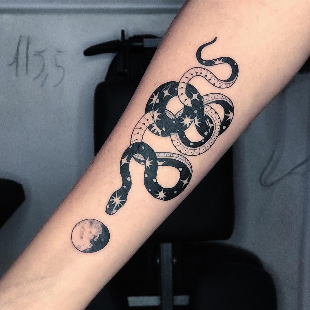 Minimalist red snake tattoo on the inner forearm