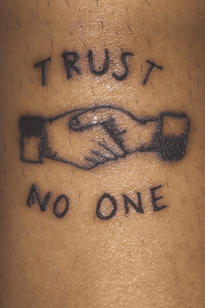 Trust No One lettering tattoo is a powerful message on the arm