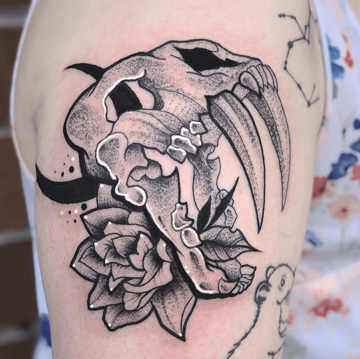 Single needle smilodon skull tattoo on the left bicep