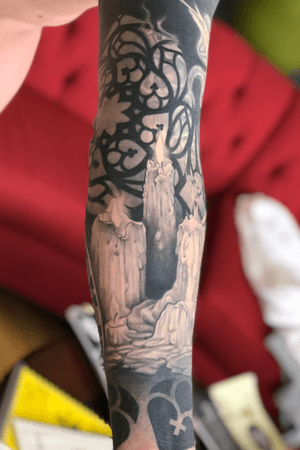 Black and gray candles on the inside of the right arm.