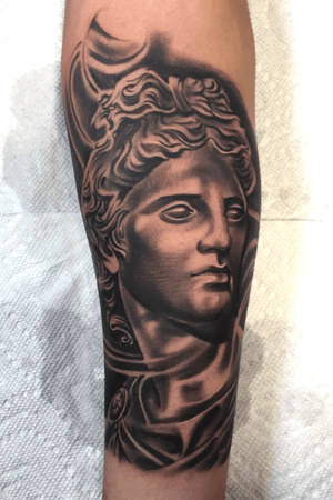 Greek God statue black and grey on forearm 
